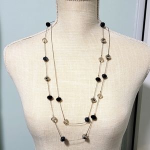 Long necklace with blue, black, and silver beads.